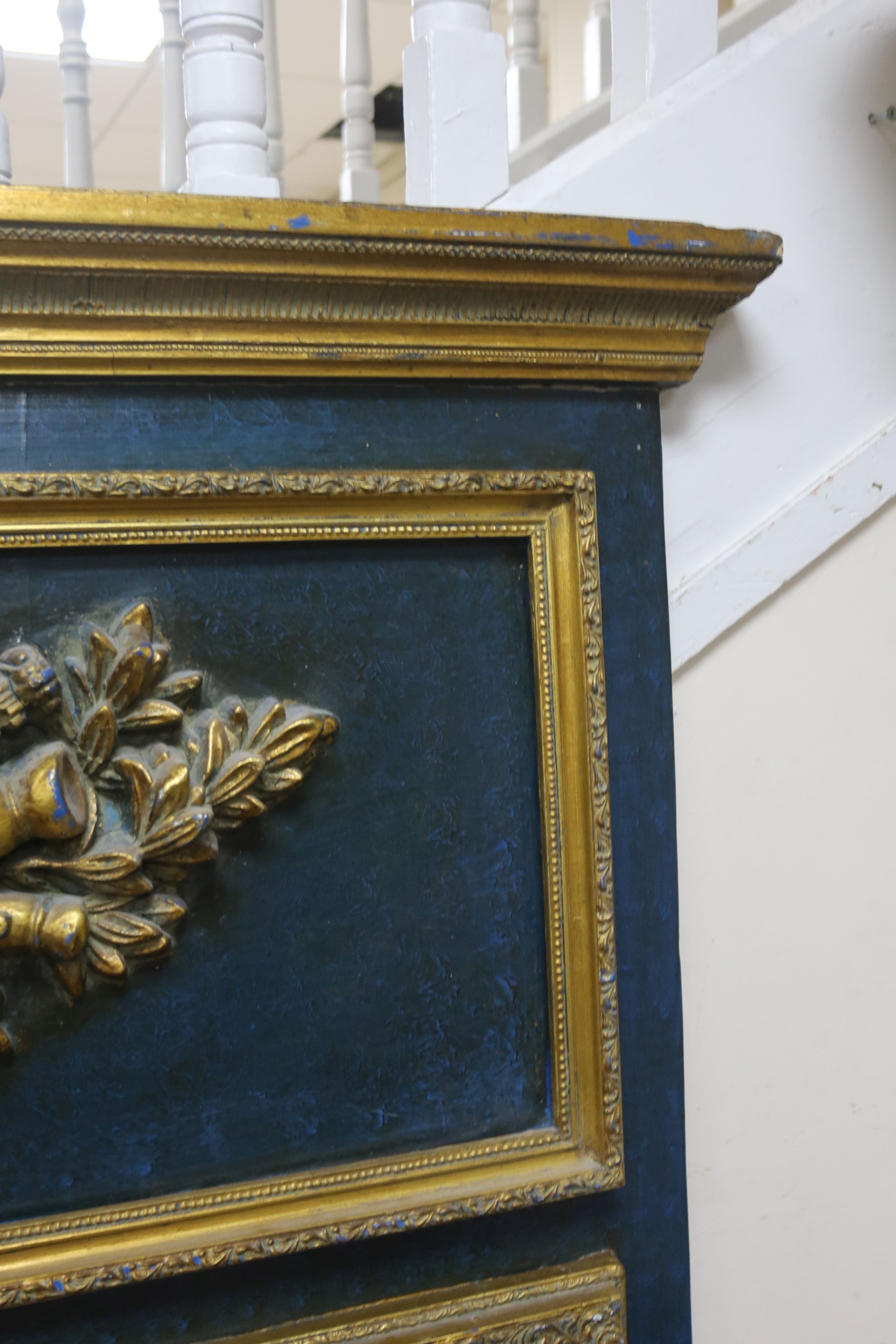 A 19th century French overmantel gilt and gesso mirror with musical themed emblem over on blue background, width 114cm, height 172cm